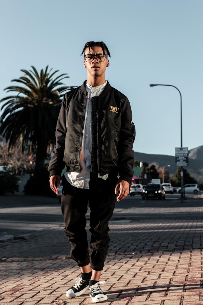 about-02 Fashionable young man in trendy streetwear standing confidently outdoors, showcasing urban style.