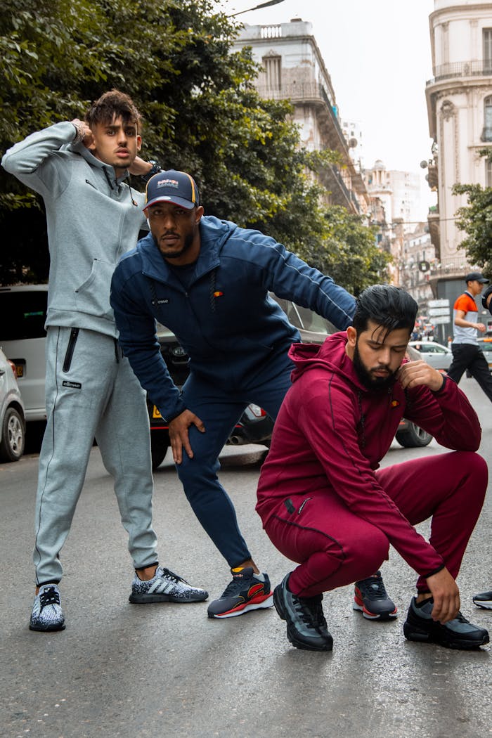 about-img Three men pose in stylish active wear on a city street, embodying modern urban fashion.